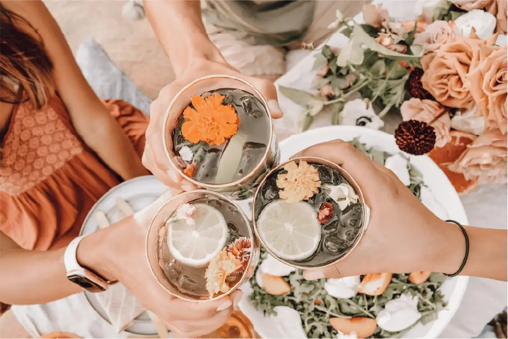 Three hands cheerings glasses over a decorated table
